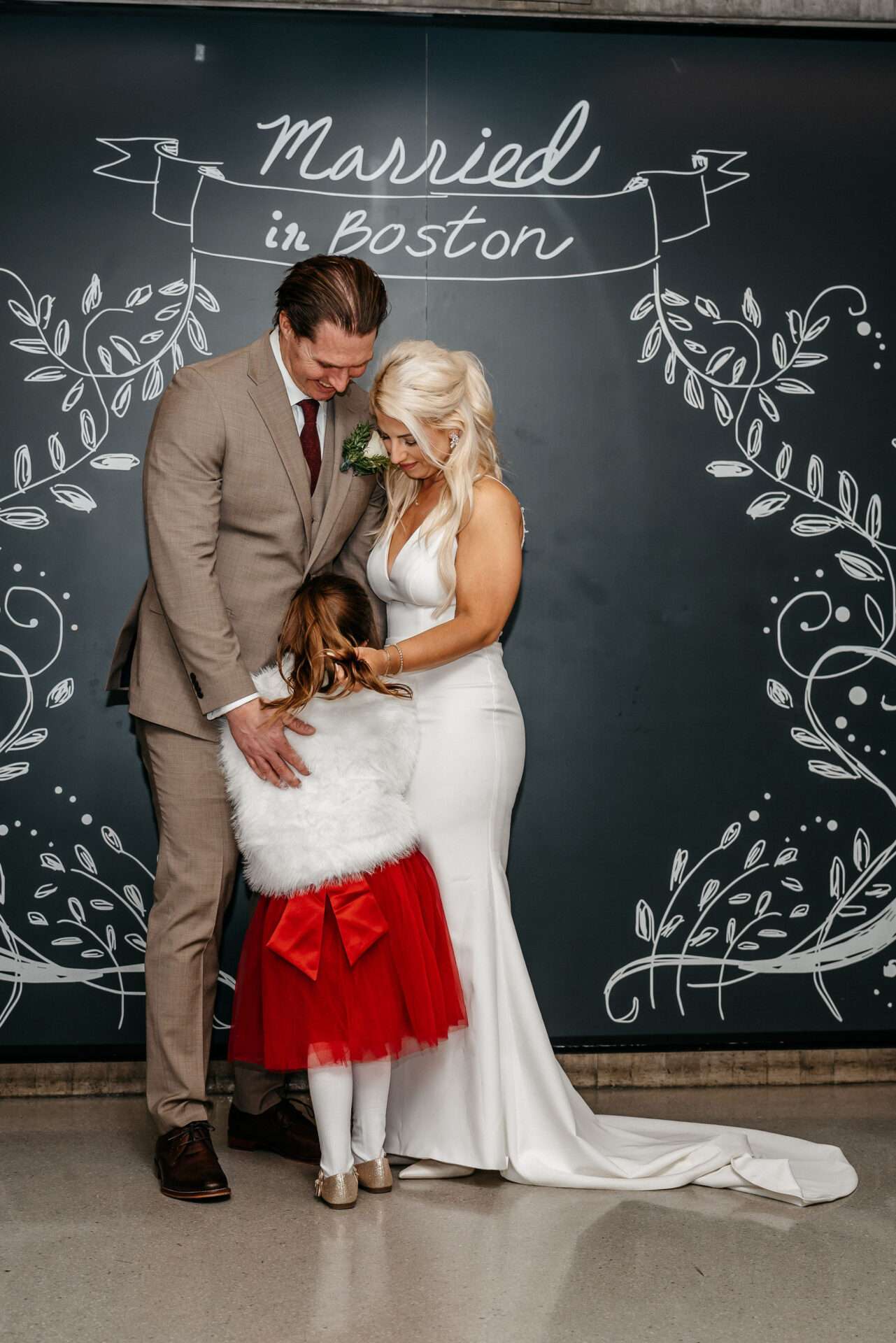 Mom and dad and daughter embrace as they get etting married at city hall in Massachusetts