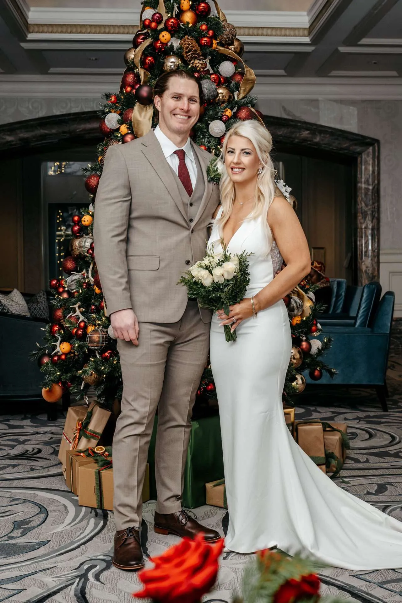 Bride and groom stand in front of a Christmas tree getting married at Boston city hall