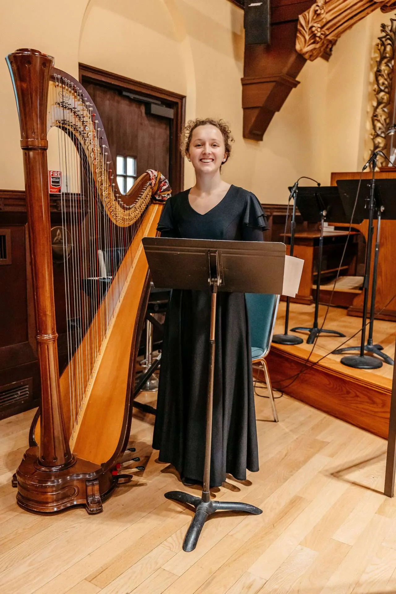 A harpist smiles and prepares her sheet music stand at small boston wedding venues