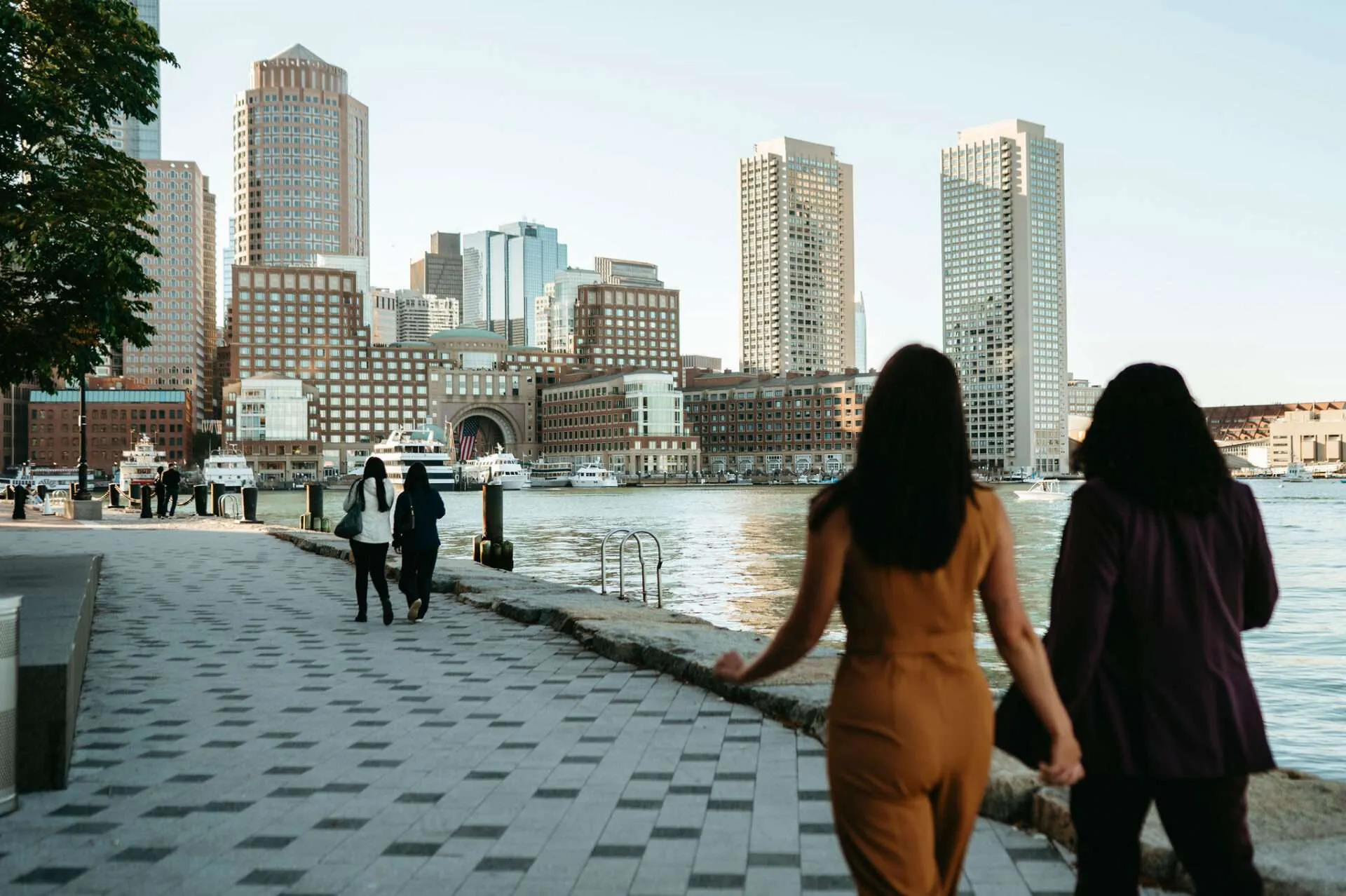 Two people who just got married walk down the harbor to small wedding venues in Boston