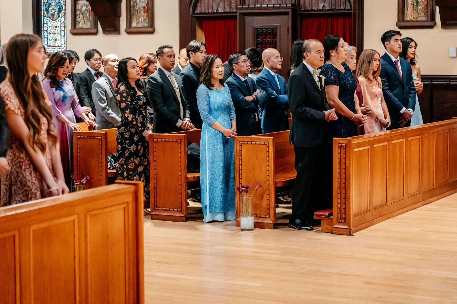 People stand at church pews at
small wedding venues for 50 guests