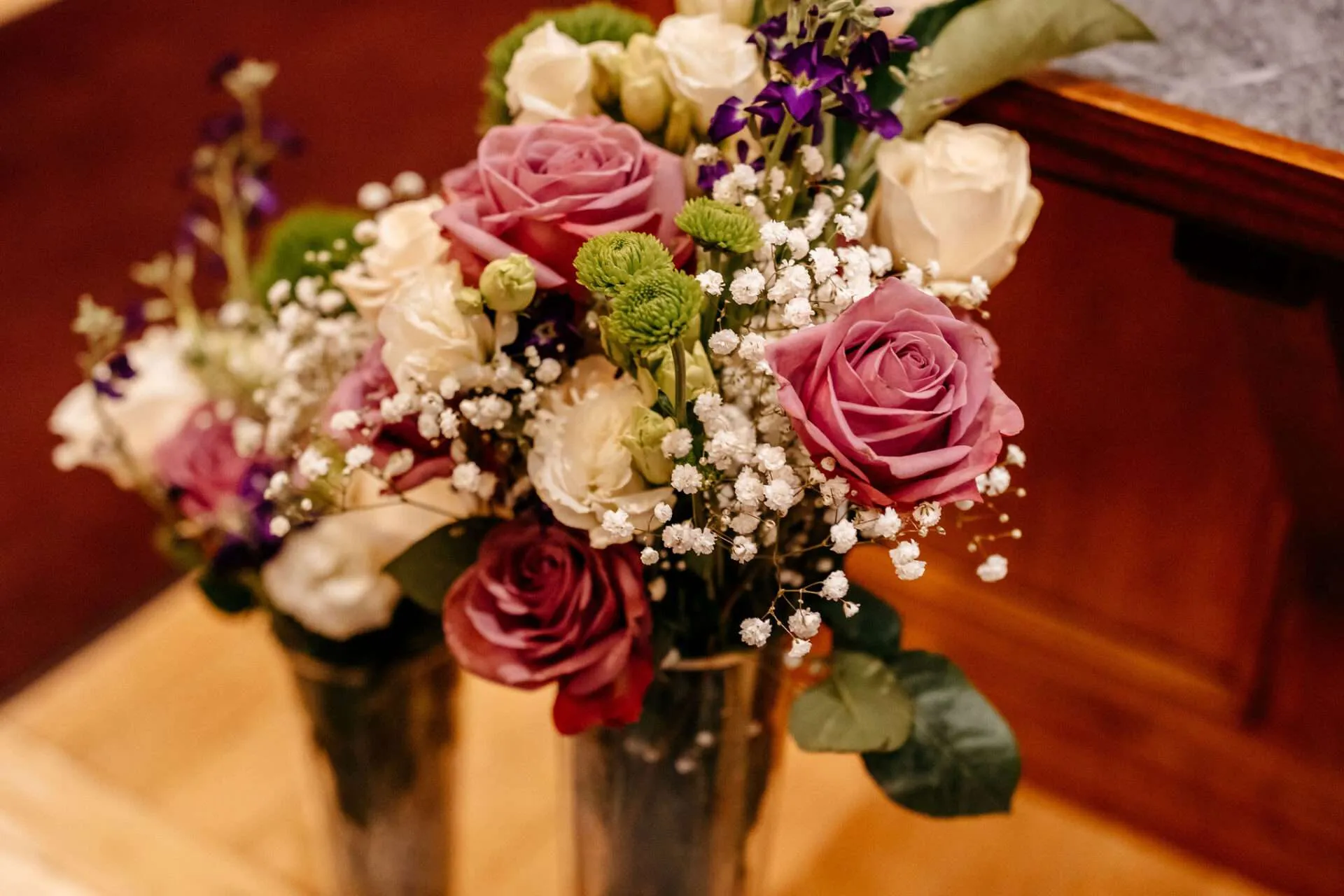 A flower arrangement of pink, white, and purple is on display at a reception by a wedding florists in boston
