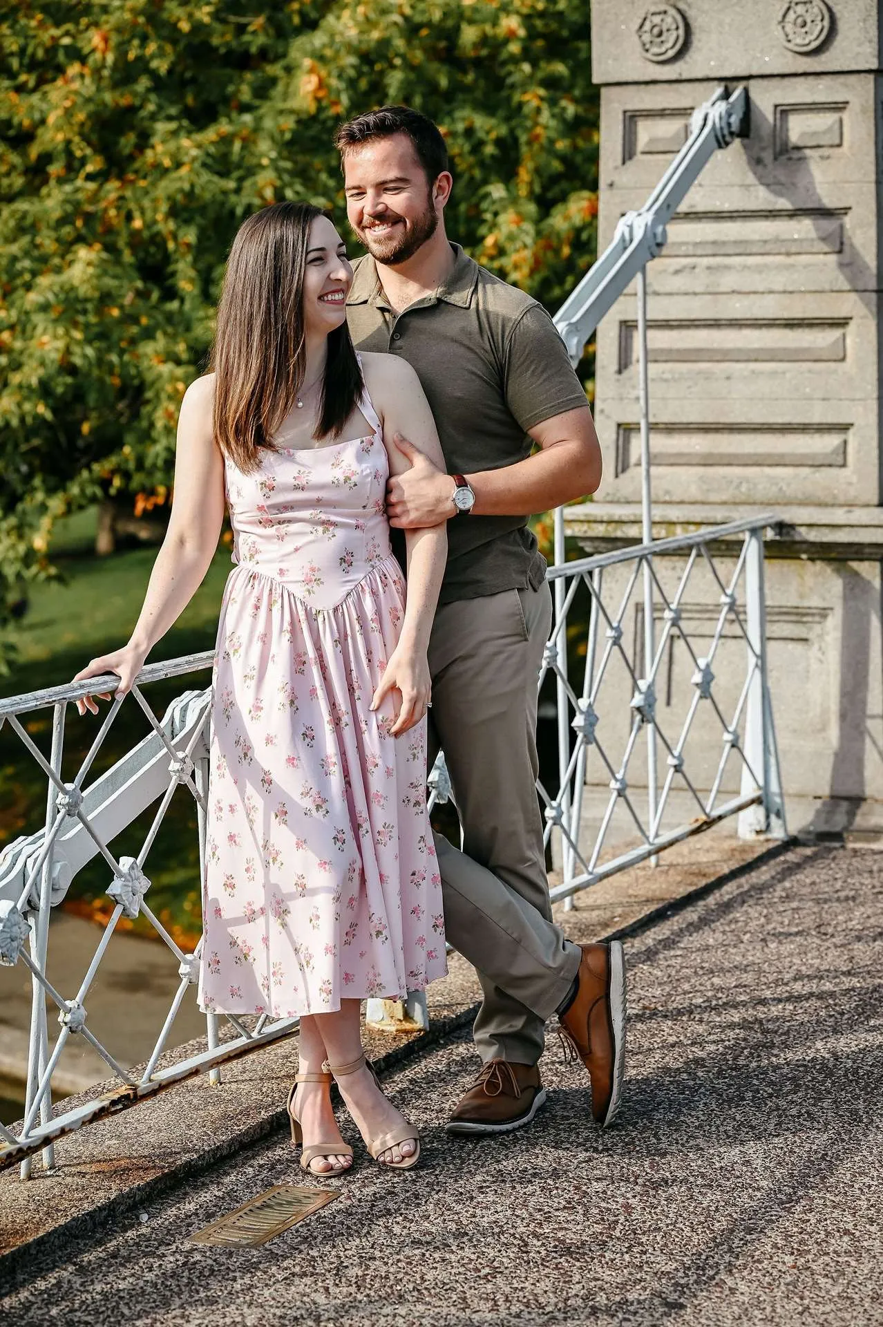 ​A couple smiles on a bridge while deciding what restaurants for date night in boston to go to.