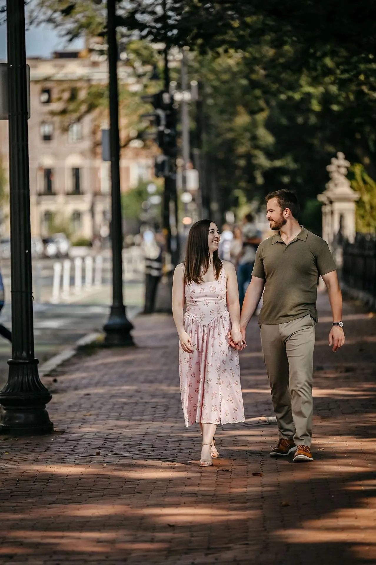 A couple walks down the street holding hands to go to one of the best restaurants in boston for date night.
