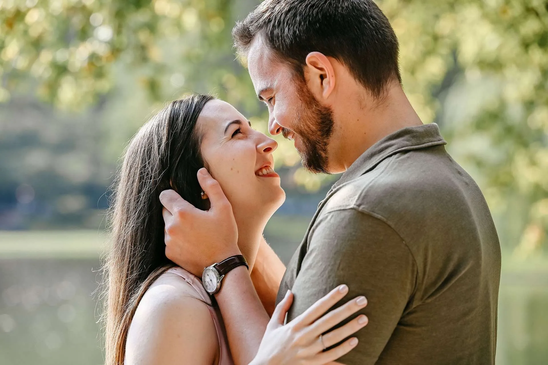 A man holds his fiance's face and smiles because they are going to one of the best restaurants in boston for date night