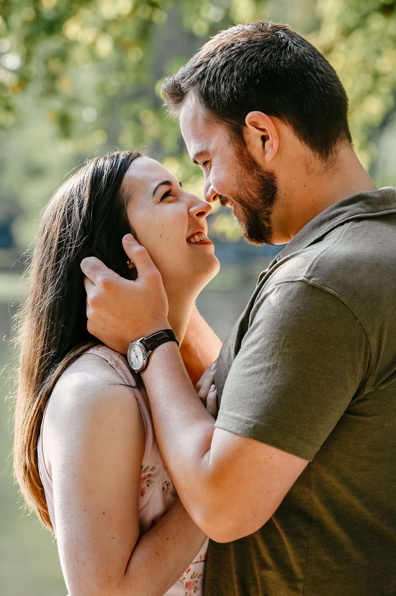 A man holds his fiance's face and smiles because they are going to one of the best date night restaurants in boston
