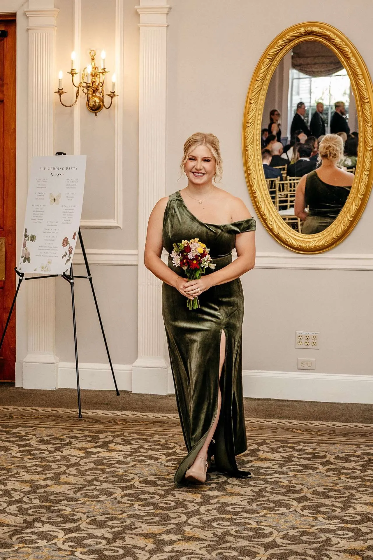 A bridesmaid in a green velvet dress walks down the aisle at boston hotels wedding venues