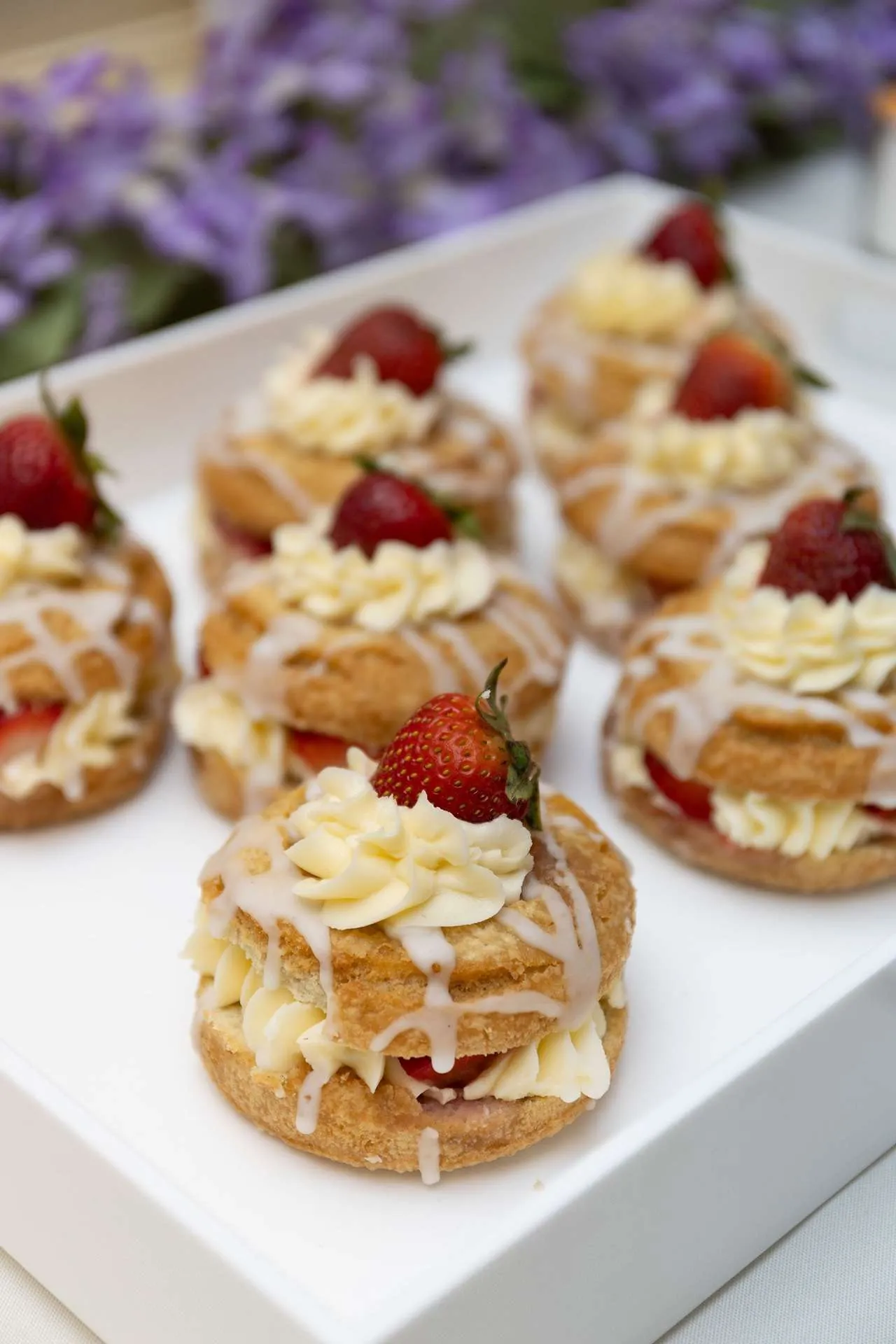 A plate of dedlicious pasteries with strawberries and cream are arranged decoratively at a reception as photographers in boston ma take photos