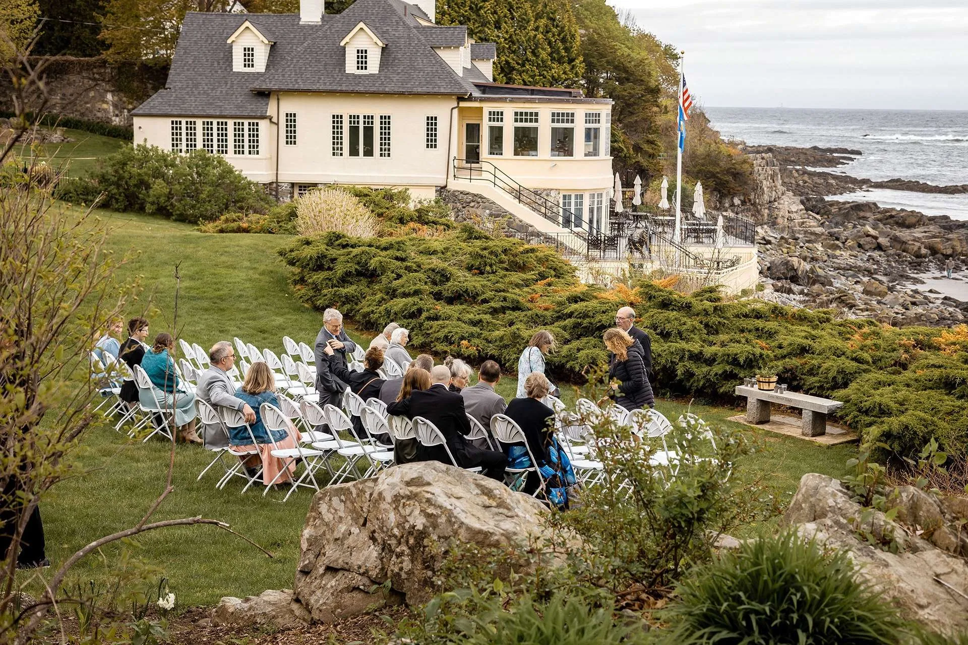 A family gathers on the coastal venue next to a white house as photographers in boston ma take photos