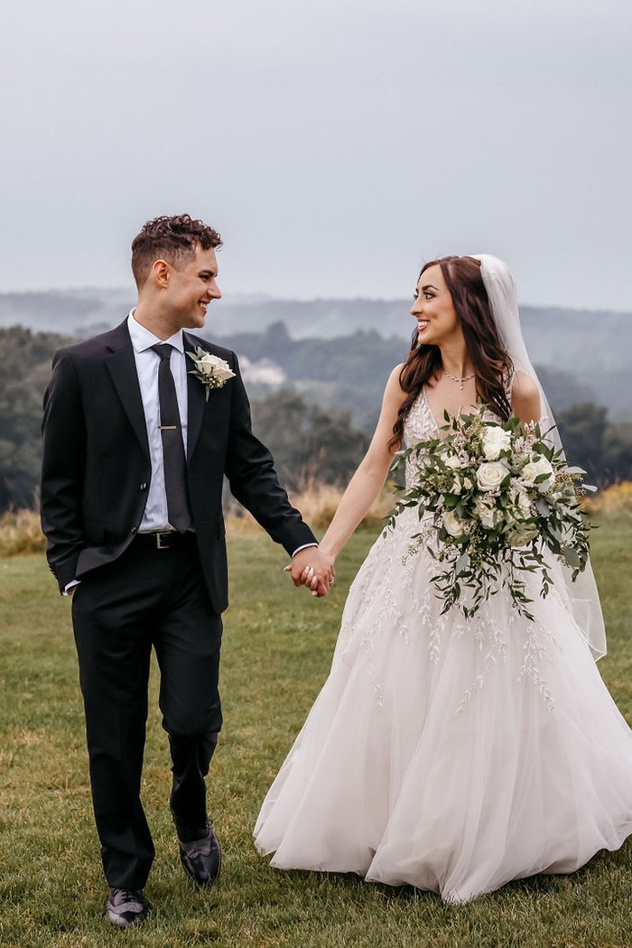 Bride and groom walking hand in hand on a misty New England hilltop – Asia & Leonard