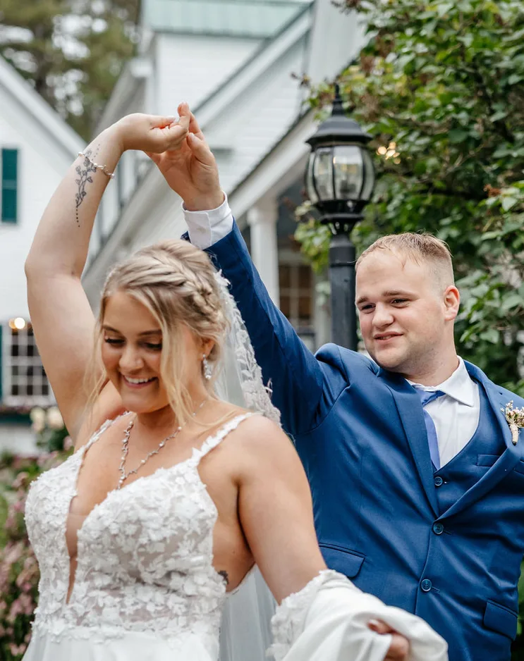 Bride and groom dancing in front of the white farmhouse at Hardy Farm, Fryeburg, Maine