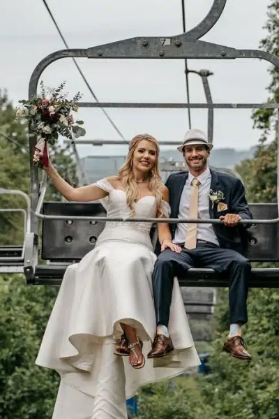 A bride and groom smile while riding a ski lift at Mount Southington Ski Area in Plantsville, Connecticut.